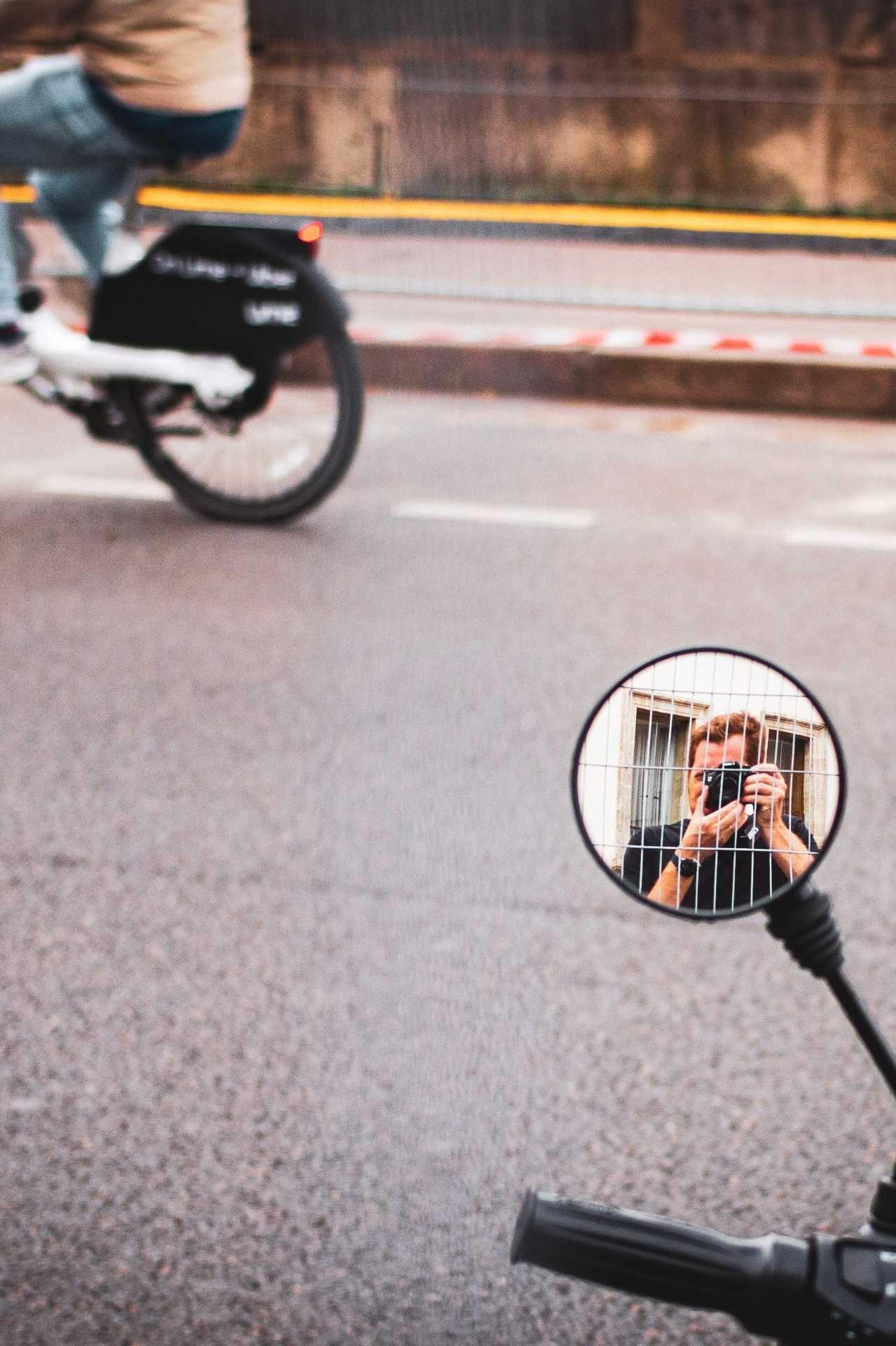 Self-portrait of the photographer reflected in a scooter mirror